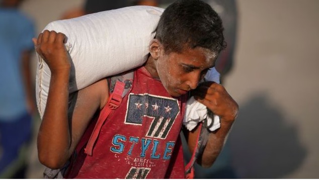 Children in Gaza awaiting humanitarian aid amidst food shortage, 2025